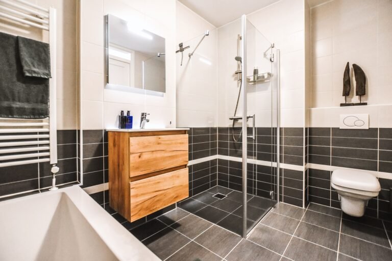 Salle de bain rénovée avec douche moderne, vasque en bois et carrelage contemporain à Rouen