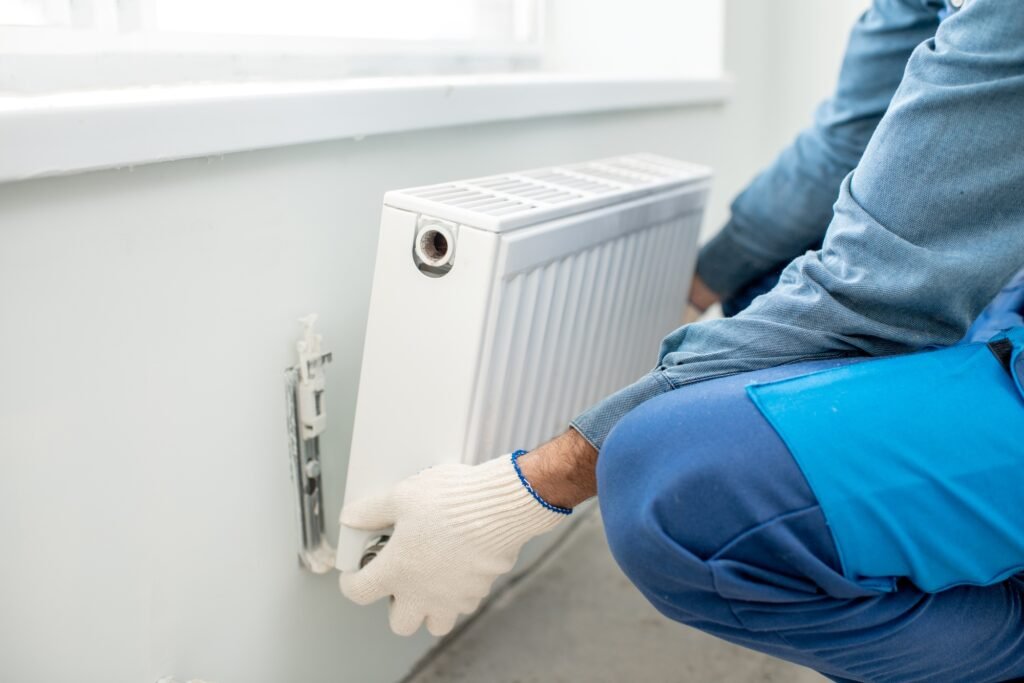 Plombier chauffagiste installant un radiateur mural pour optimiser le chauffage d’un logement à Rouen